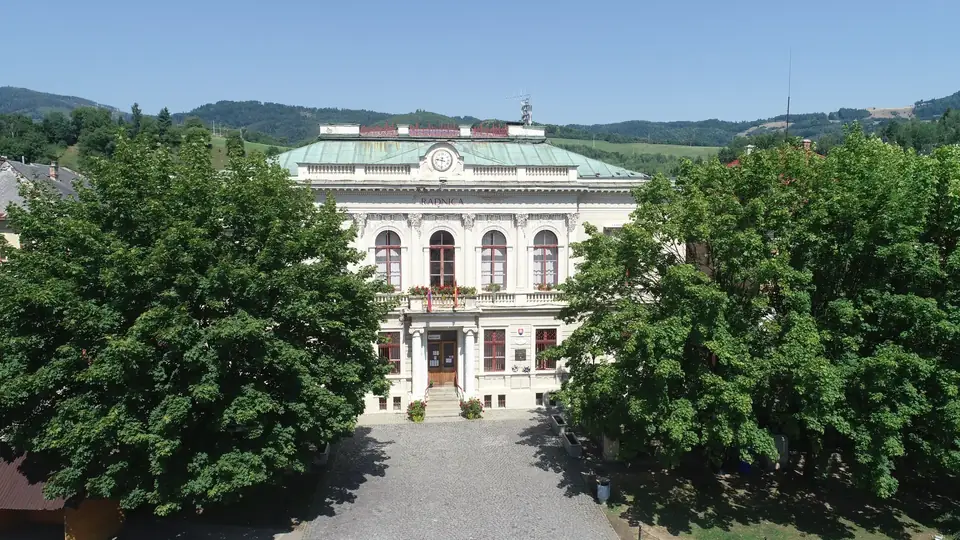Priečelie historickej radnice v Dobšinej medzi stromami.